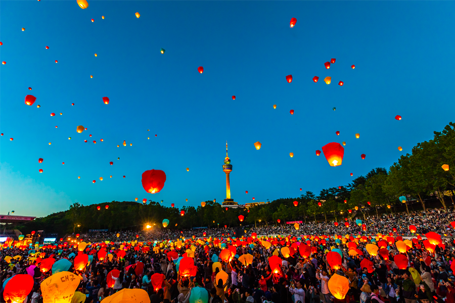 大邱的庆祝活动，夜空中升起的彩灯和充满欢庆气氛的人群，展现了大邱活力四射的城市文化，吸引游客深入体验当地节日氛围。