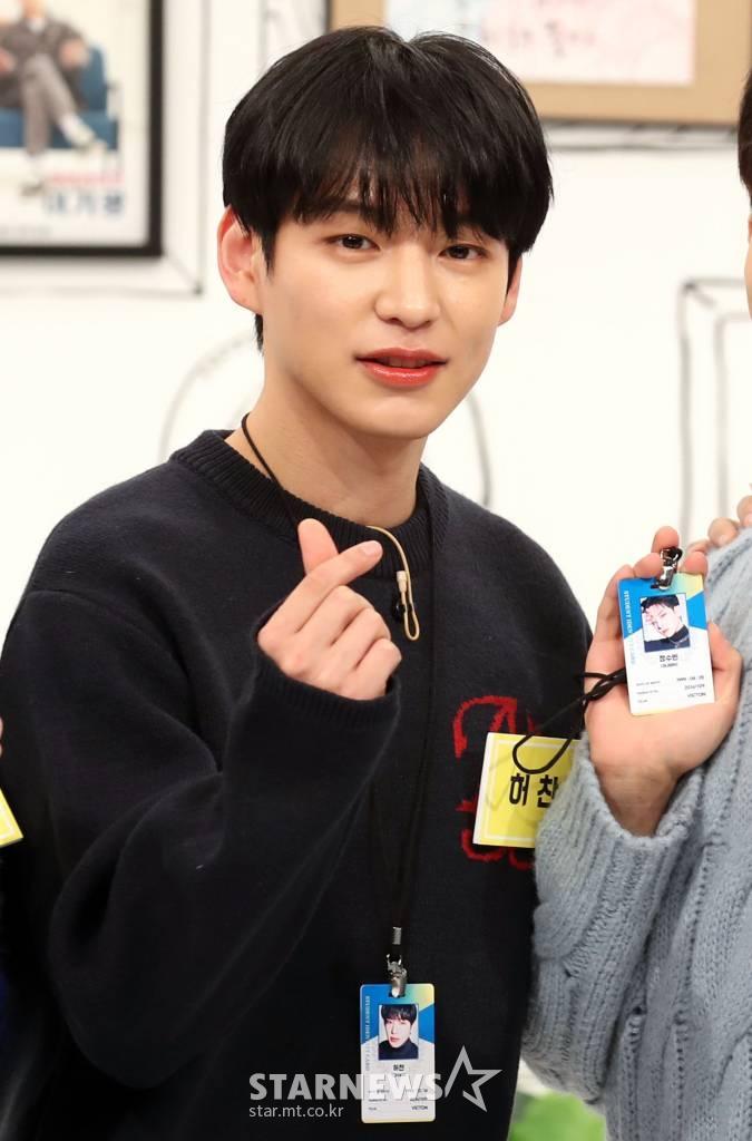 VICTONのイベント参加者がIDカードを持ちながら、手でハートを作るジェスチャーをしている。スターニュースの著作権。