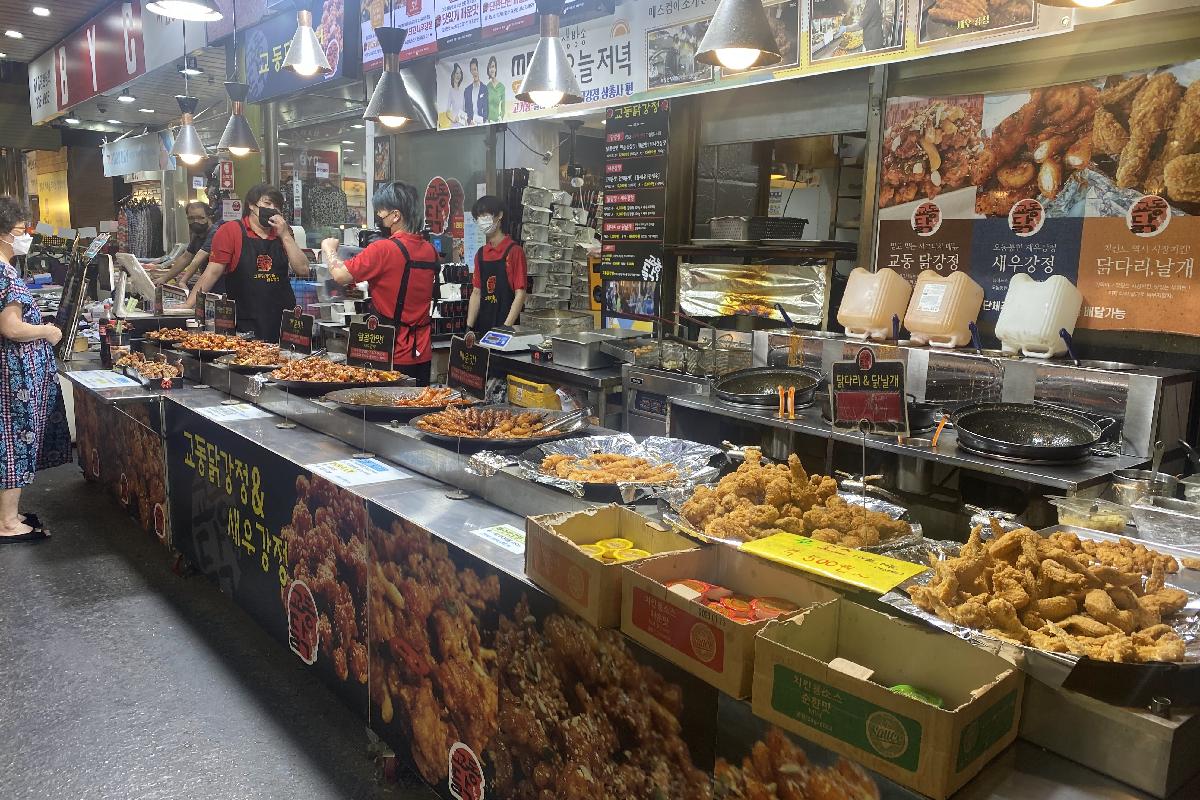 Stand de poulet frit sur le marché de Mangwon à Séoul, avec une variété de plats frits exposés