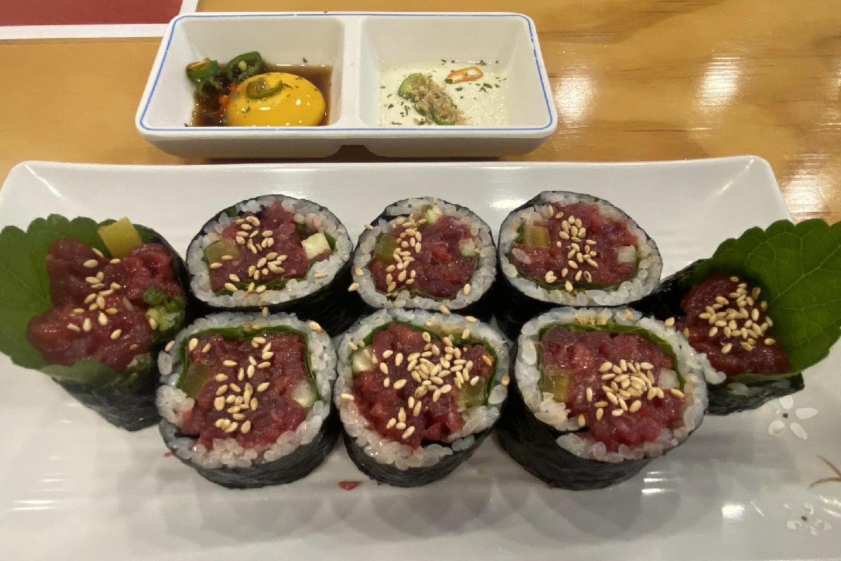 Plat de yukhoe kimbap présenté sur une assiette blanche, décoré de graines de sésame