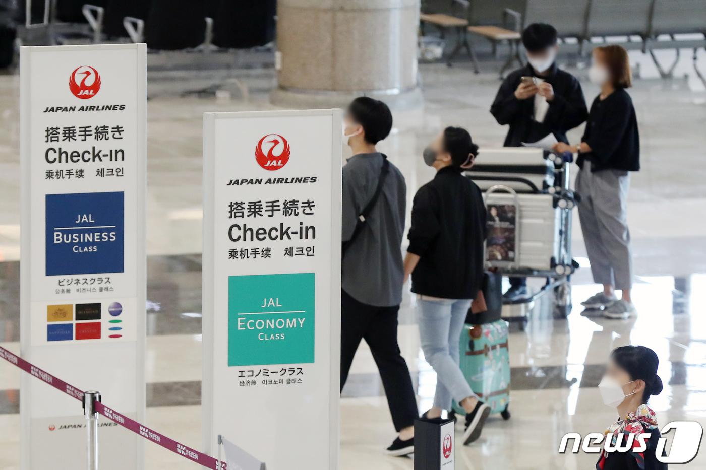 ソウル金浦空港で日本航空のチェックインカウンターに並ぶ旅行客たち