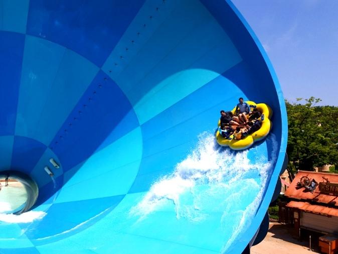 Abenteuerliche Wasserrutsche in Caribbean Bay mit Gruppenboot in einer blauen Röhre