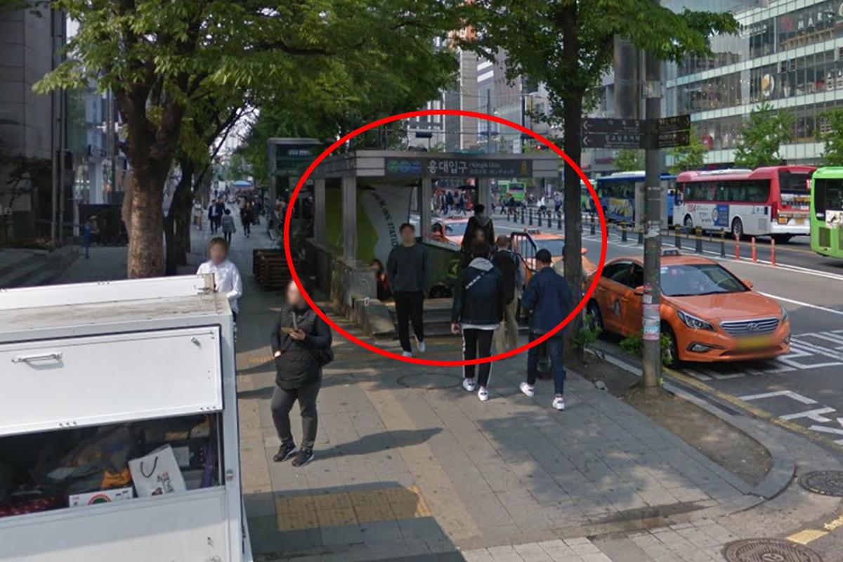 在首爾弘大入口站8號出口，賓客正在站台門口集合準備參加雪嶽山、南怡島、晨靜樹木園一日遊，背景顯示首爾的城市景觀與紅色出租車。