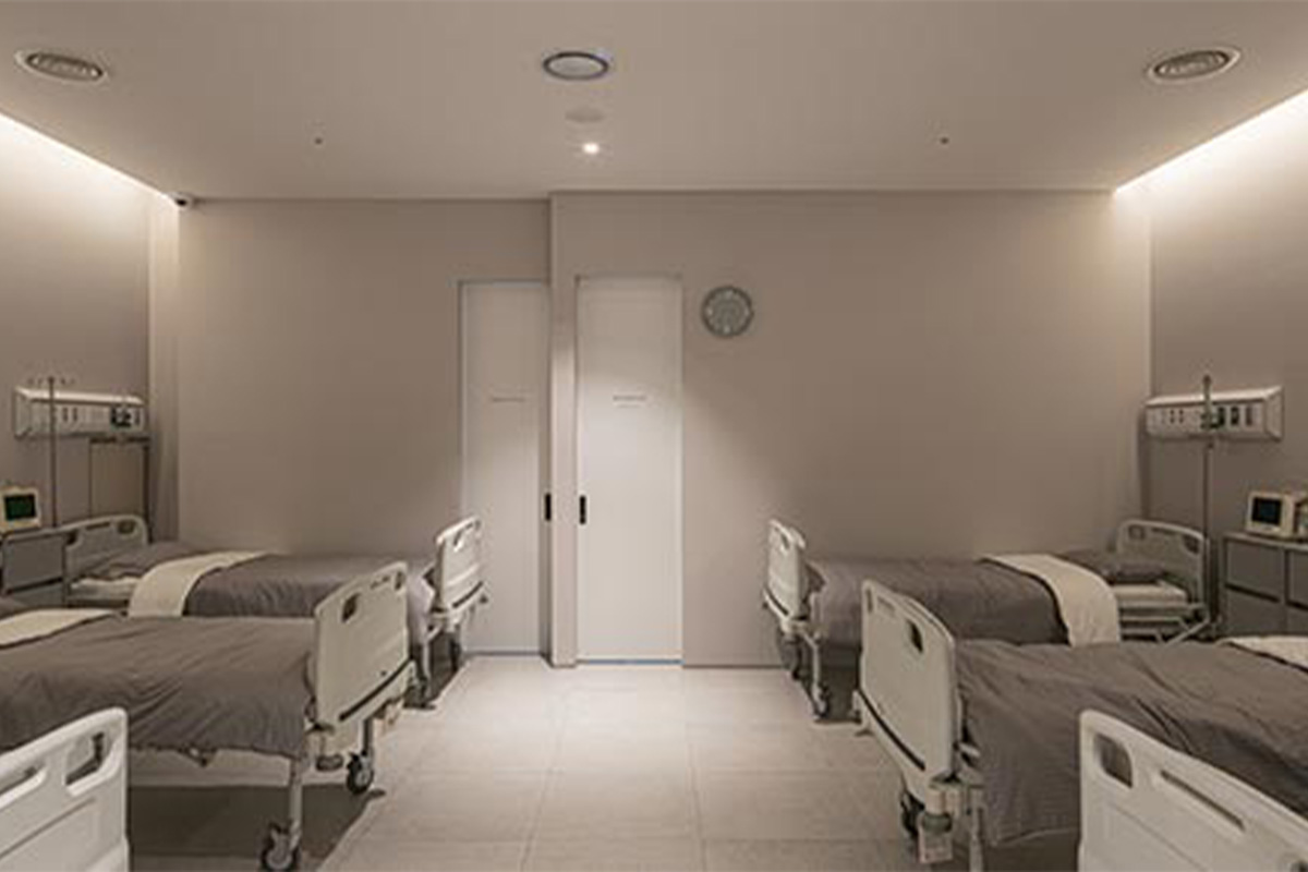ห้องพักผู้ป่วยของ V Plastic Surgery ที่มีเตียงสำหรับการพักฟื้นหลังการผ่าตัด