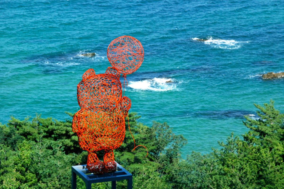 Escultura jugando con el viento en Haslla Art World, contrastando con el azul del Mar del Este.