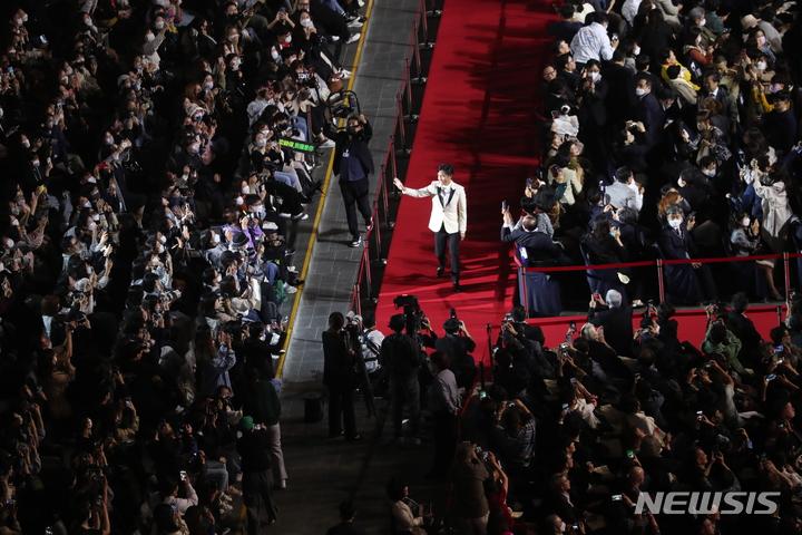 釜山国際映画祭でレッドカーペットを歩くトニー・レオン。観客とカメラマンが集まる様子。2022年10月5日、釜山海雲台区で開催。