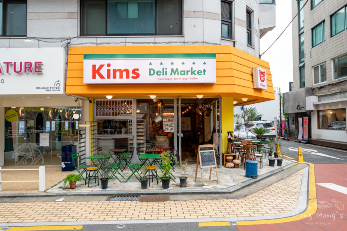 首尔蚕室松理团路的一家鲜艳的便利市场，市场前放置了绿色桌椅作为户外座位。