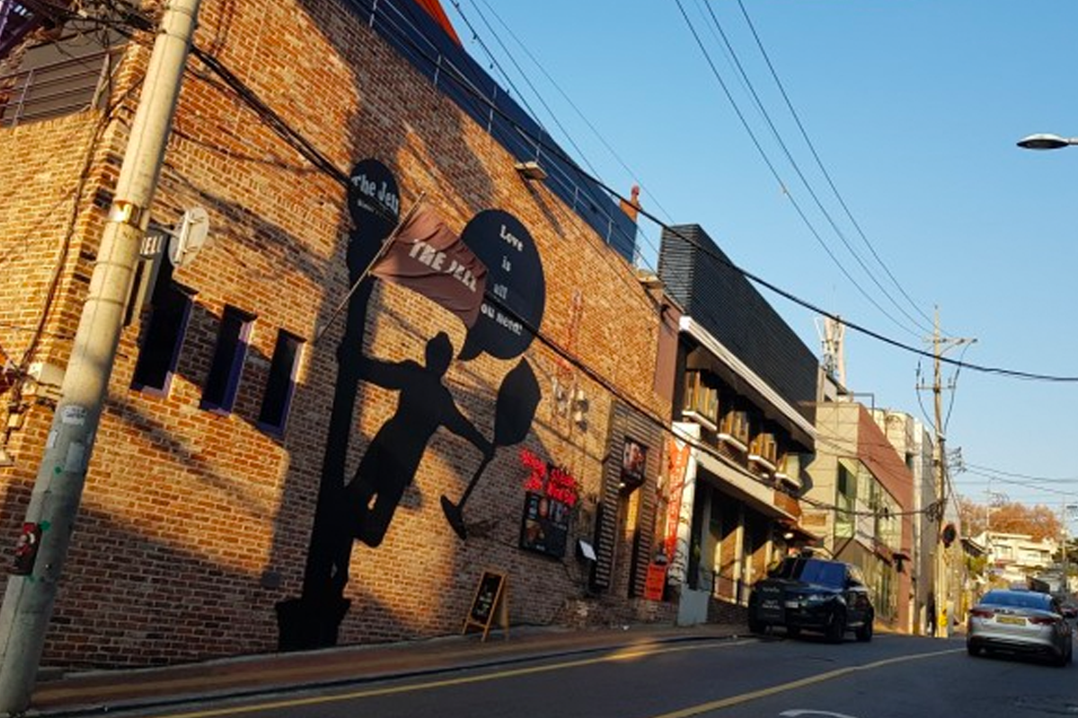 被称为经理团路风格的街道，砖墙上的壁画和街道上停泊的车辆营造出一派工艺感。