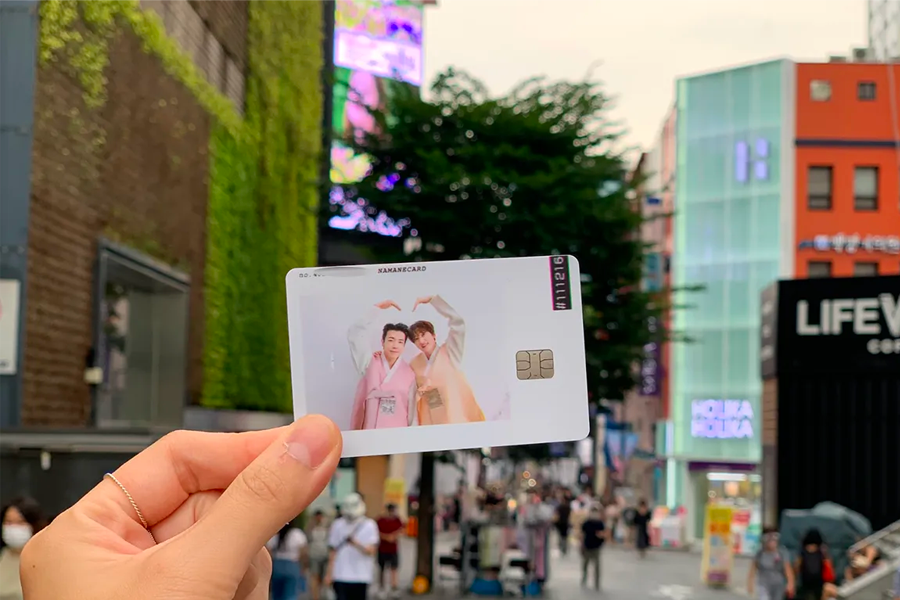 广场背景下展现的Namane卡片，反映韩国为游客提供信用卡服务的便利。