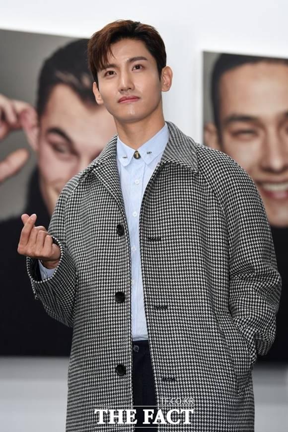 東方神起のチャンミンがモノトーンのハウンドトゥースコートを着て、インタビューに答えている姿