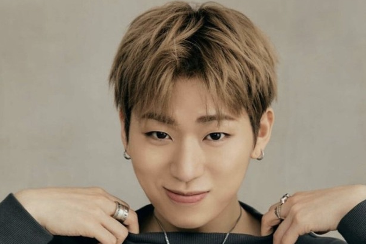 手上戴着多枚戒指的男子，背景为灰褐色。