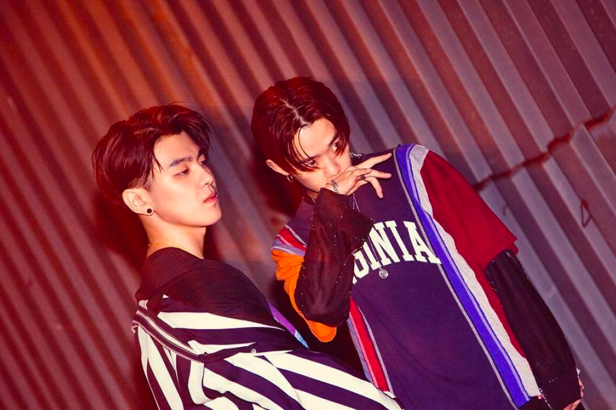 穿着色彩鲜艳衣服的两个男子在昏暗的环境下拍摄的一张酷炫的照片。