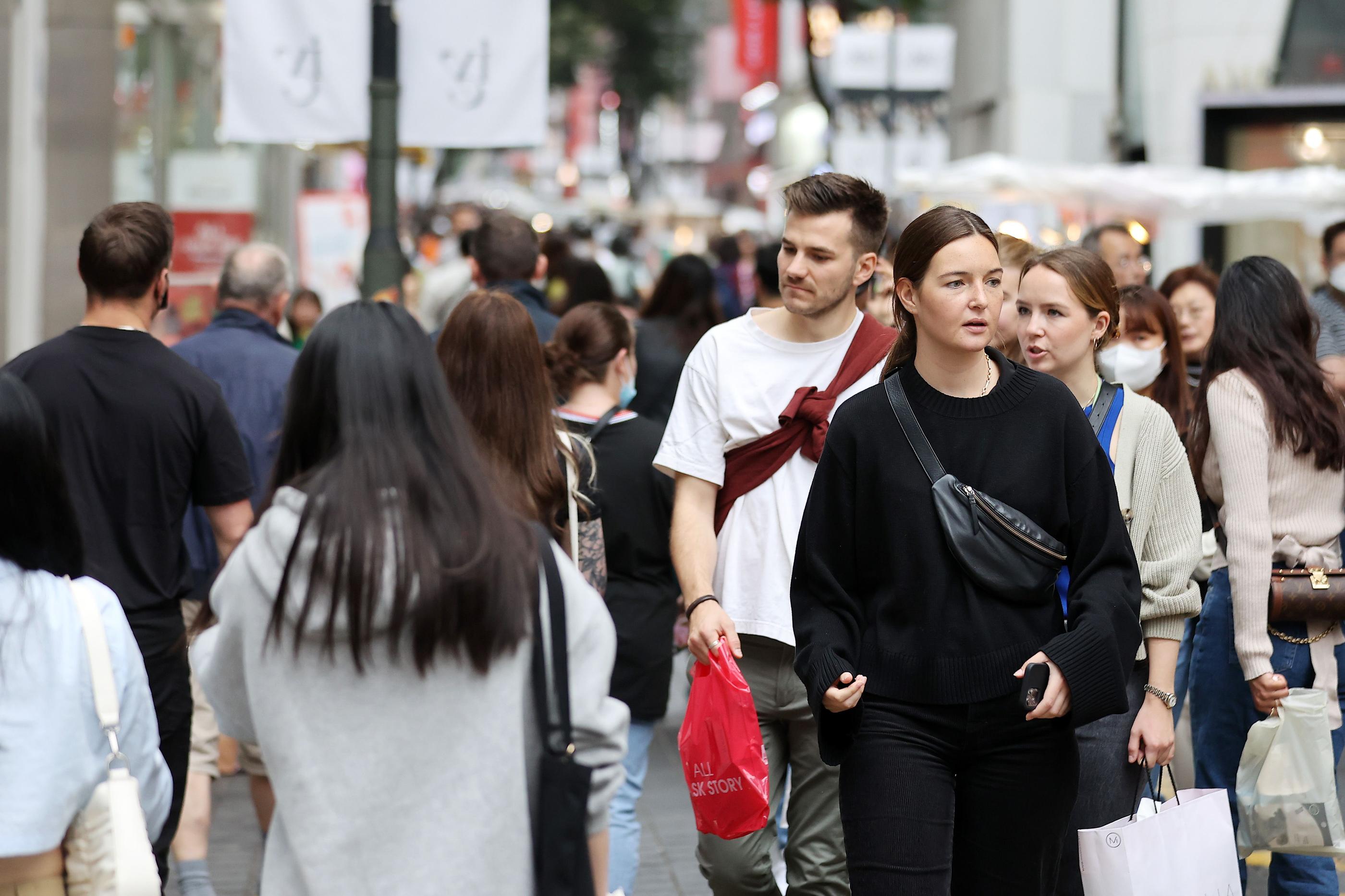 ソウルの明洞通りで歩く外国人観光客と市民たち。ノービザ入国再開により、韓国の繁華街が賑わいを取り戻しつつある。