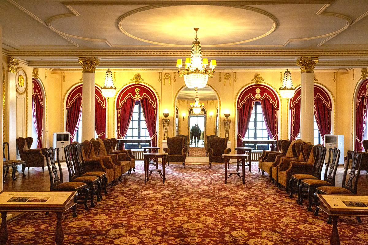 Salle intérieure luxueuse du Seokjojeon, avec ses rideaux rouges, lustres et mobilier royal au Palais Deoksugung.