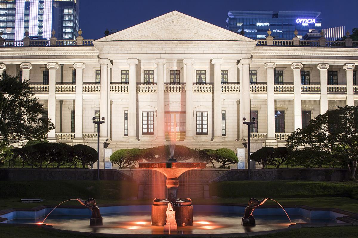Seokjojeon du Palais Deoksugung, illuminé la nuit avec une vue sur la fontaine avant le bâtiment.