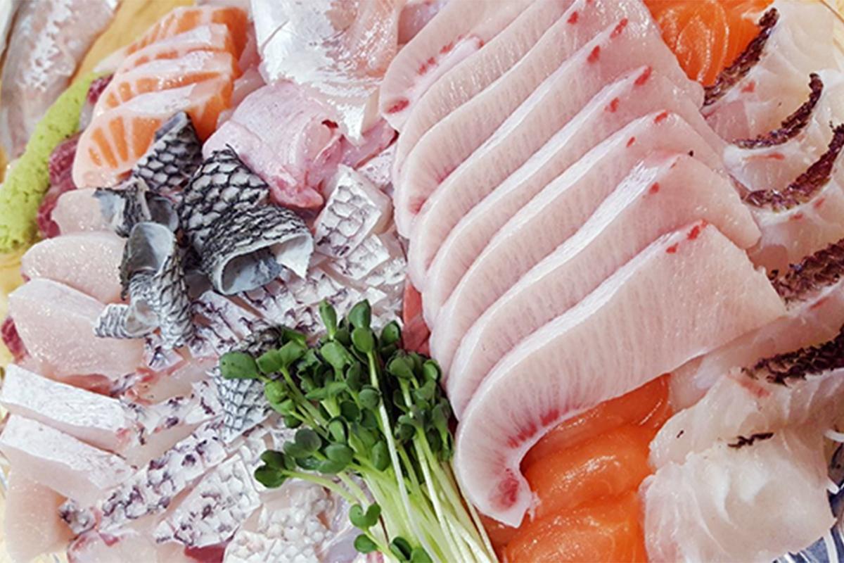 Assiette de sashimi fraîchement préparé sur le marché de Noryangjin, représentant la qualité des fruits de mer proposés.