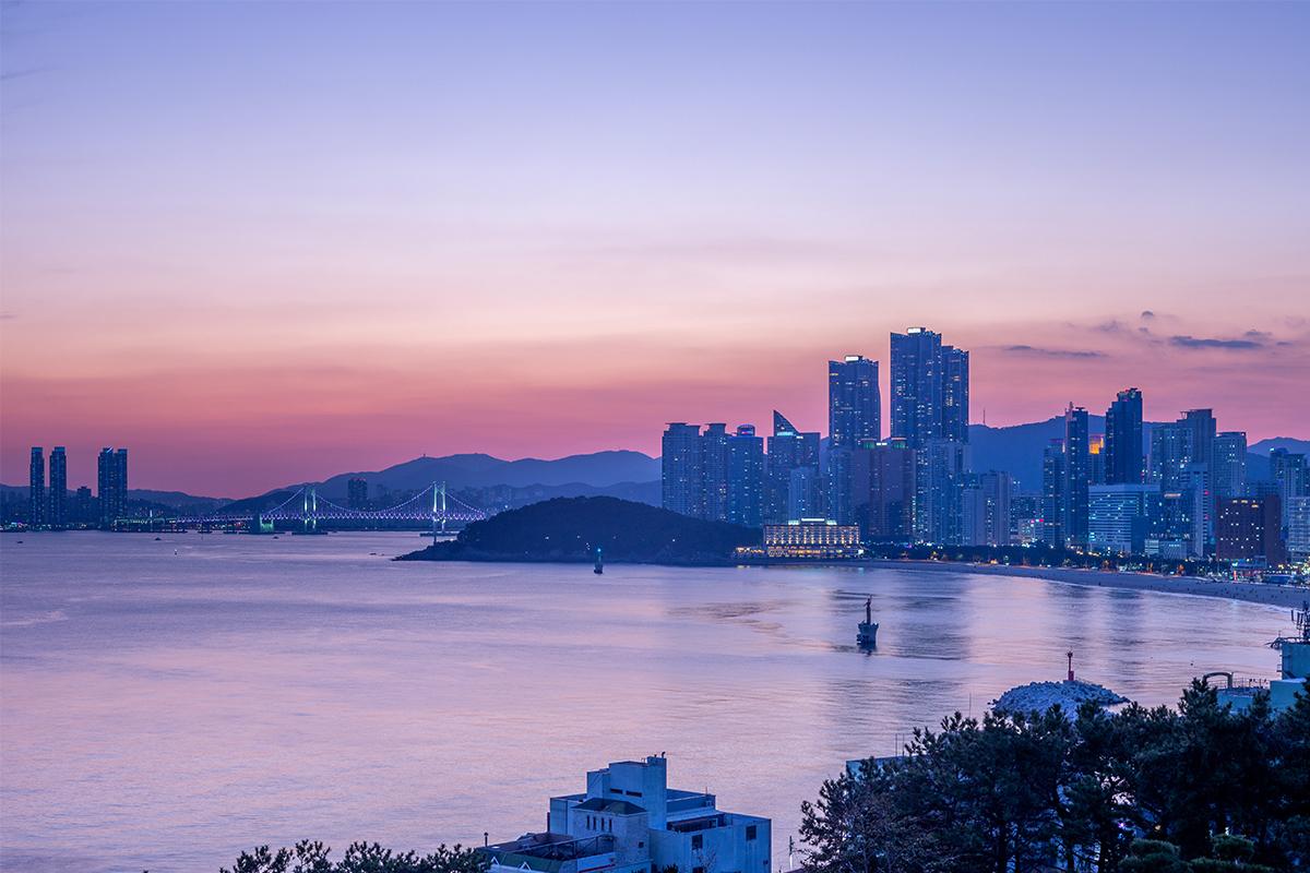 Vista nocturna de Busan desde Haeundae, mostrando el skyline iluminado y el puente Gwangan.