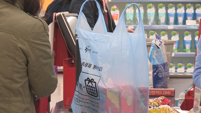 顾客在韩国零售店使用专用垃圾袋而非一次性塑料袋，响应韩国限塑令的举措。