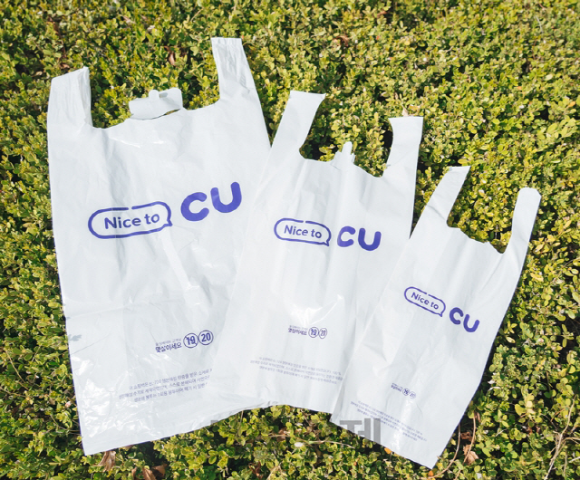 韩国便利商店展示CU塑料袋，讨论禁止使用一次性塑料袋的政策影响。