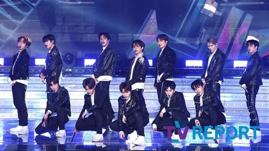 TREASUREのメンバーがステージでパフォーマンスをしている写真。