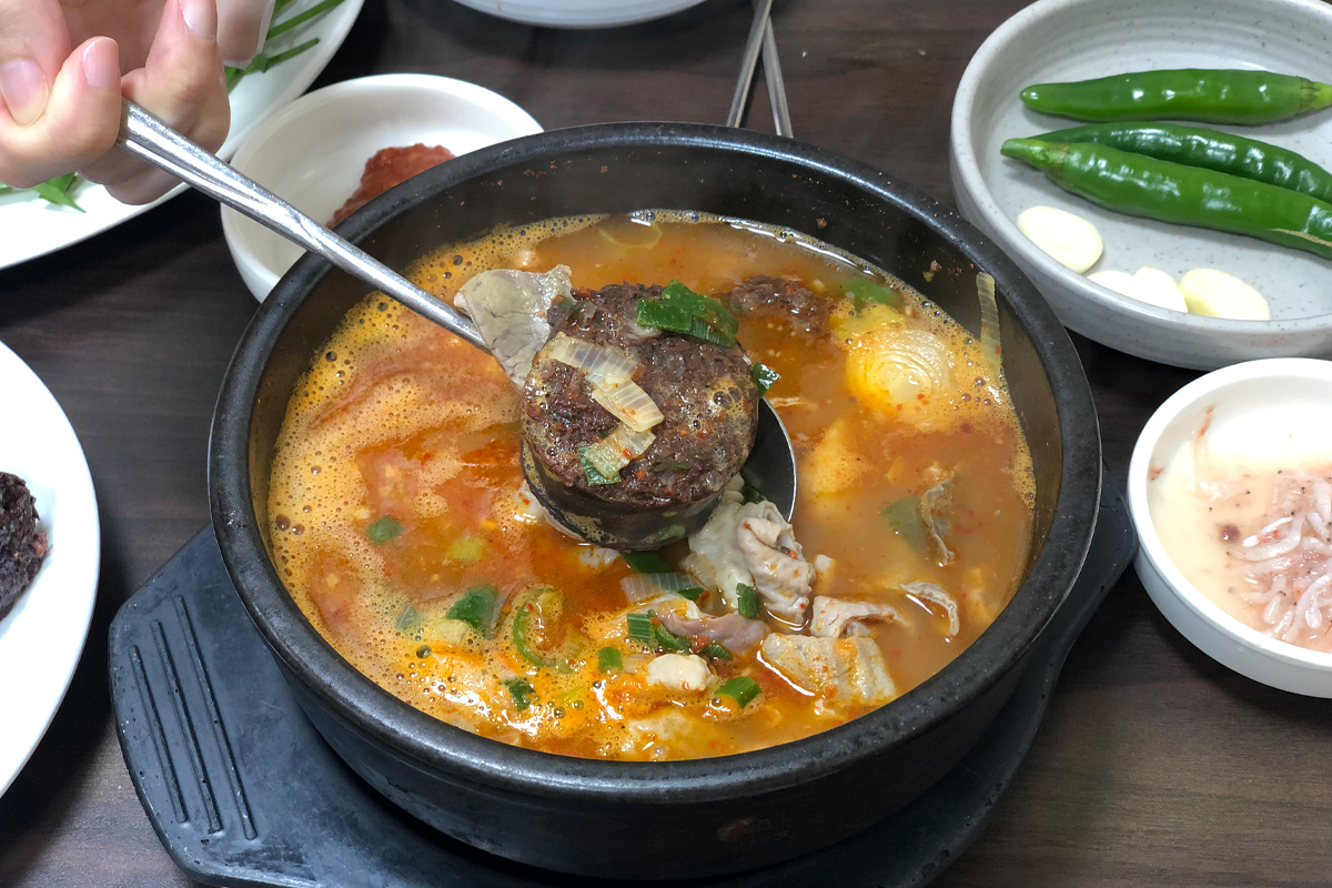 Njồi Pig Sundae đang được múc ra từ nồi canh tại Jojeomrye Nammun Pi Sundae, Jeonju