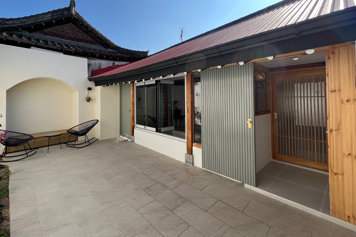 Sảnh ngoài trời của homestay trên Airbnb, Jeonju với ghế thư giãn và không gian hanok truyền thống kết hợp hiện đại