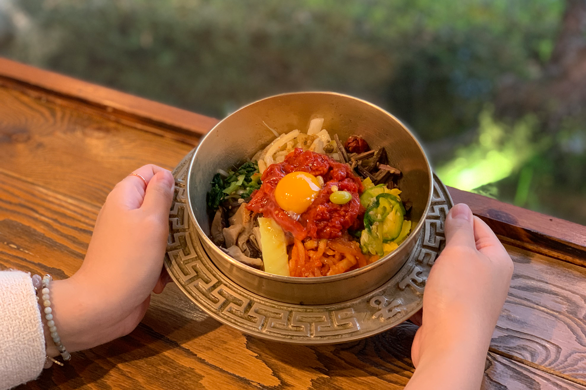 传统黄铜碗中的全州生牛肉拌饭，搭配新鲜的蔬菜，让人食指大动。