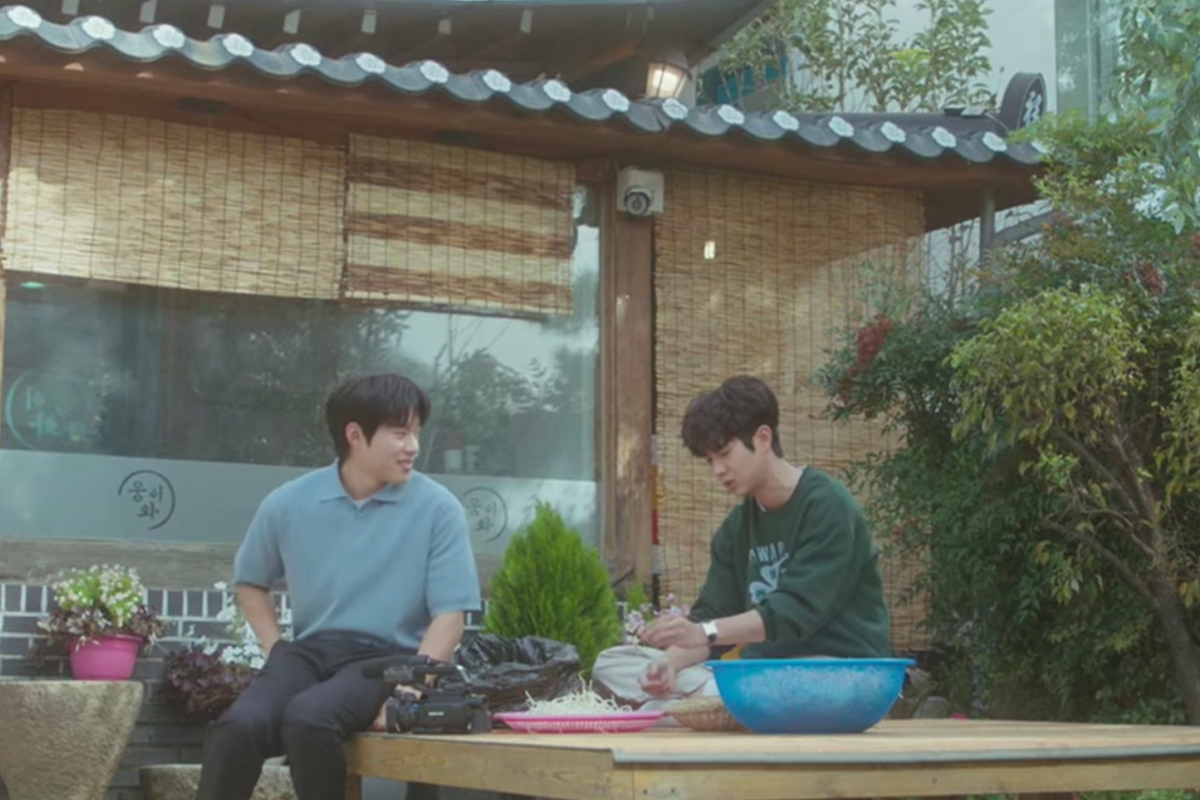 Cảnh từ phim Mùa hè yêu dấu của chúng ta với hai nhân vật trò chuyện ngoài trời tại nhà hàng Maedang