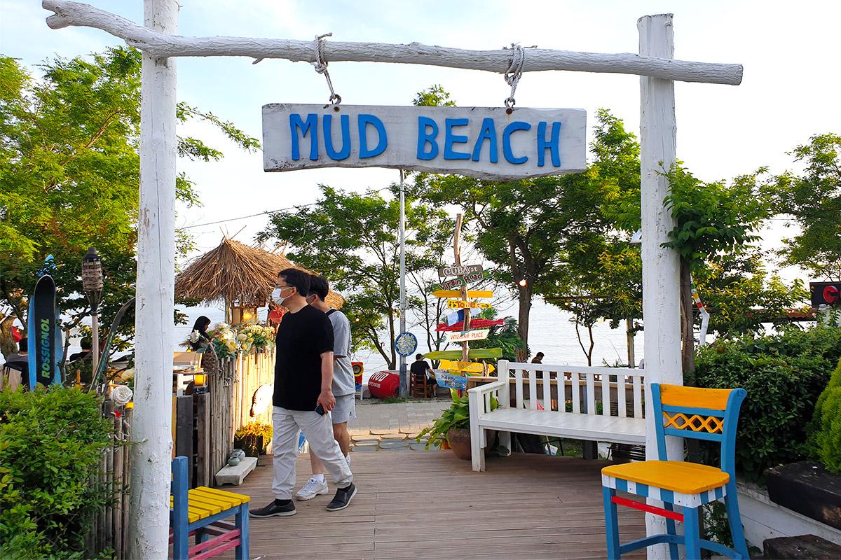Entrance to MUD Beach with a sign and seating area, offering a welcoming and relaxed atmosphere on Dangneomeo Beach.