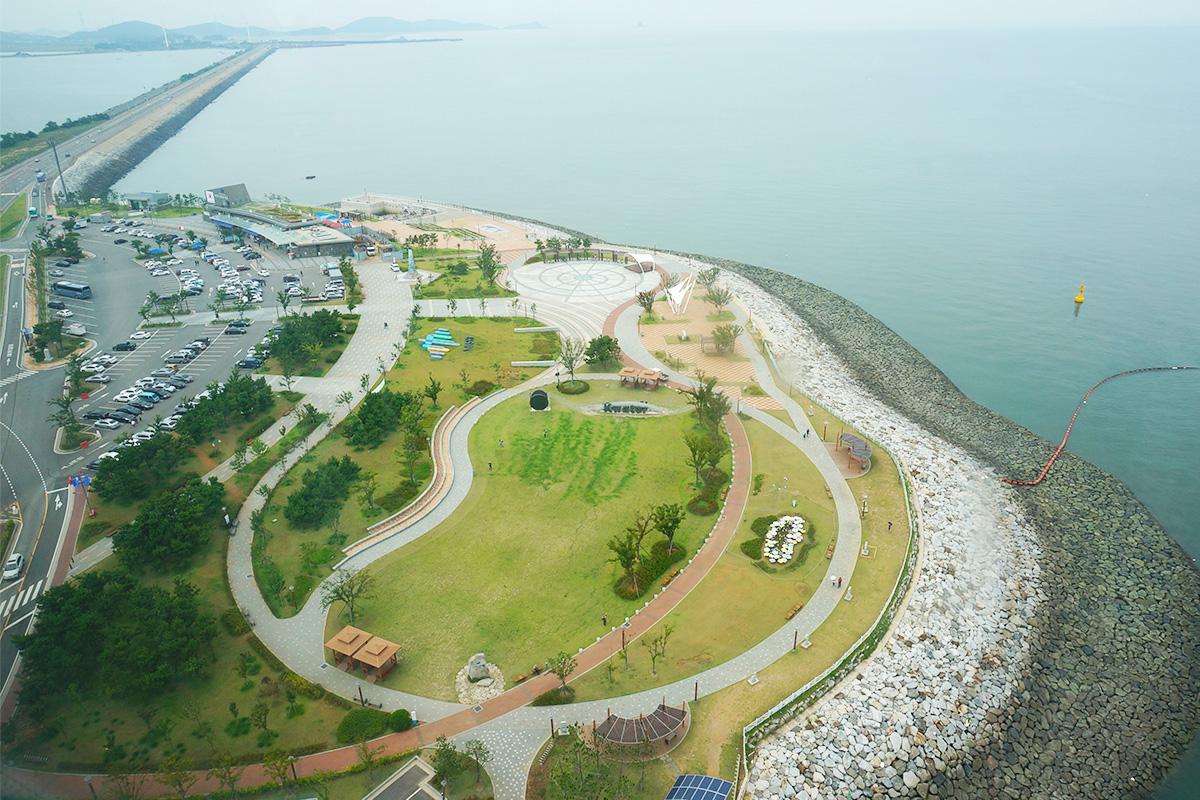 Aerial view of the park and infrastructure near Sihwa Lake in South Korea, highlighting the coastline and surrounding facilities.