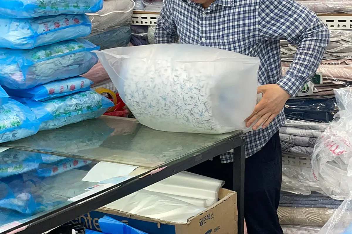 廣藏市場賣棉被嘅地方展現出滿滿嘅棉被，色彩繽紛嘅選擇襯托出韓國傳統市場嘅吸引力。