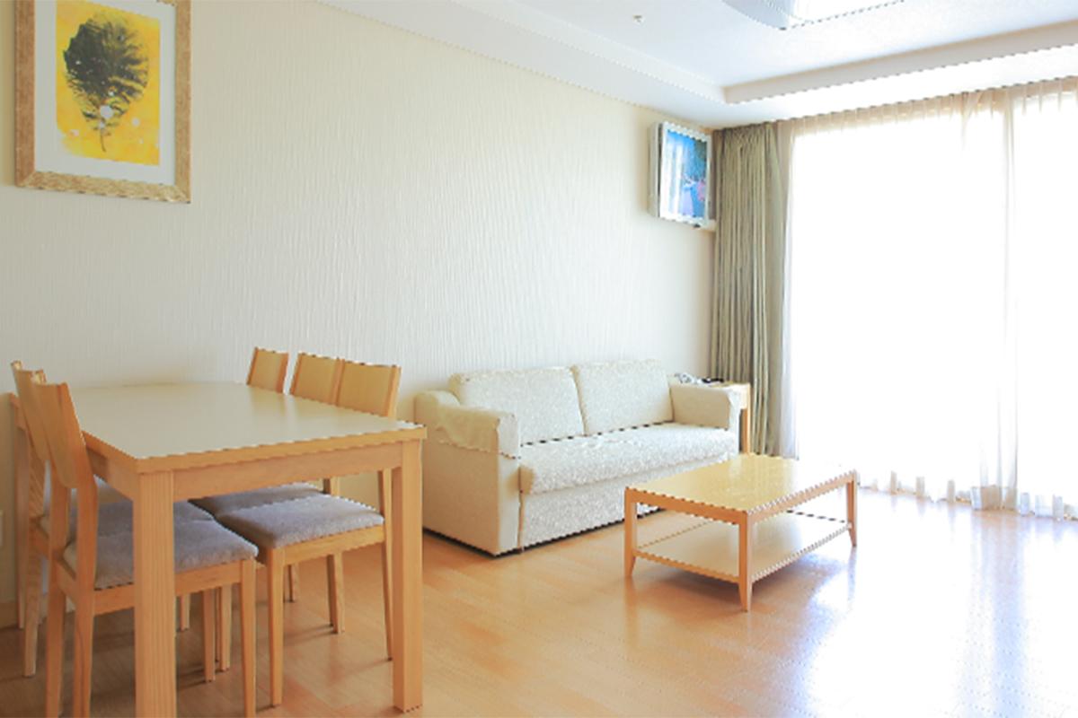 Dining and living area in a western-style condo at Greenpia Condo with a sofa and dining table.