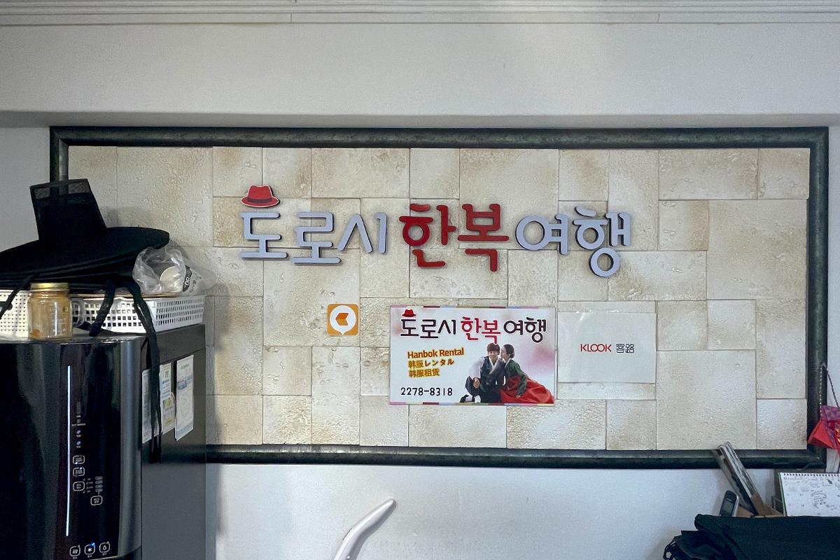서울의 도로시에 위치한 한복 대여 지점 내부 벽에 걸린 한복 대여 가게의 전경 사진. 고급스러운 벽장식이 인상적입니다.
