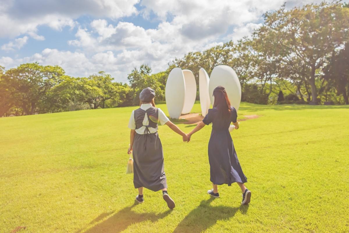 Visitors enjoying the scenic outdoors at Jeju Osulloc Tea Museum, with its iconic tea-themed installations