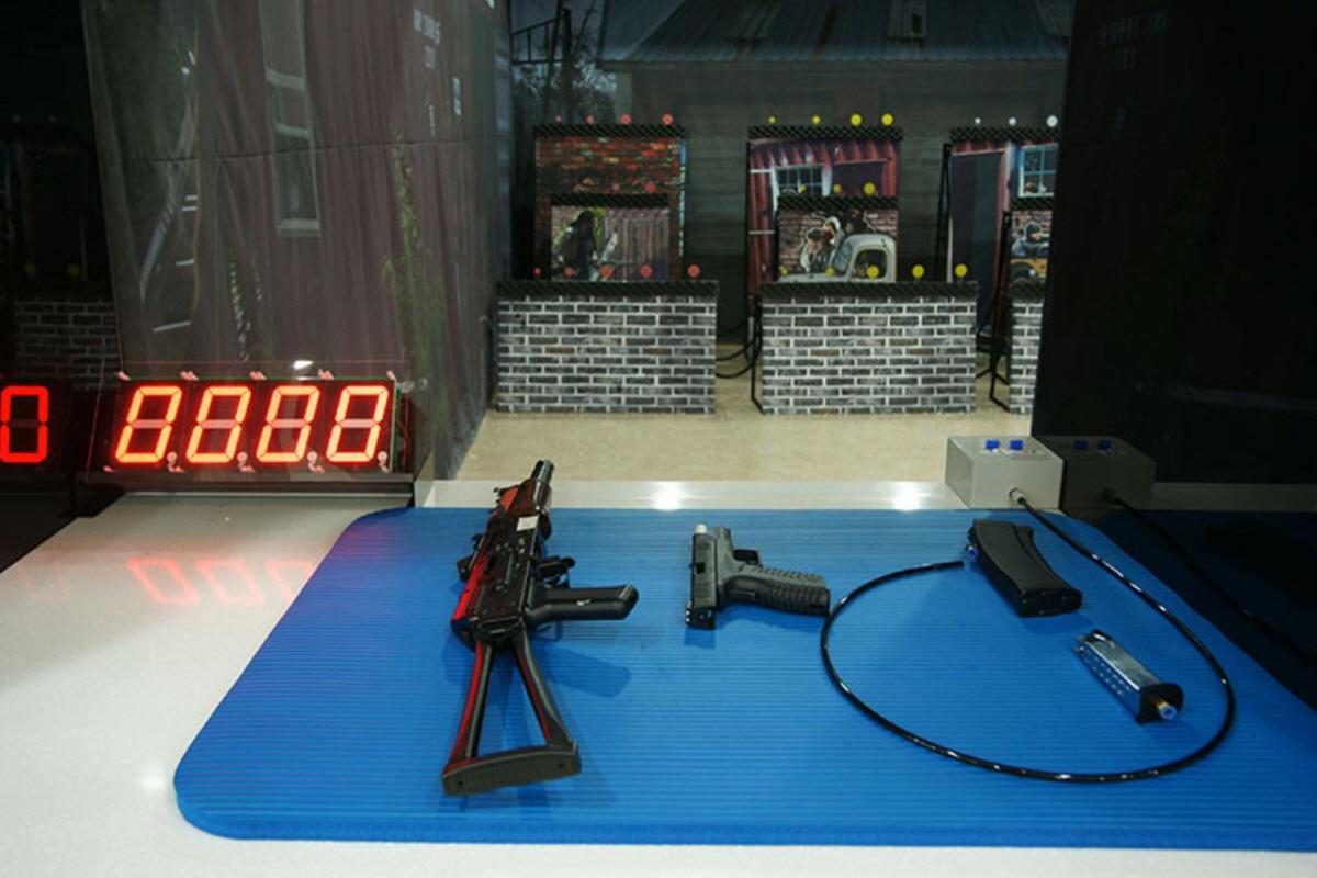 Bản súng và phụ kiện trên bàn xanh tại Trường bắn súng Jeju, sẵn sàng cho trải nghiệm bắn BB.