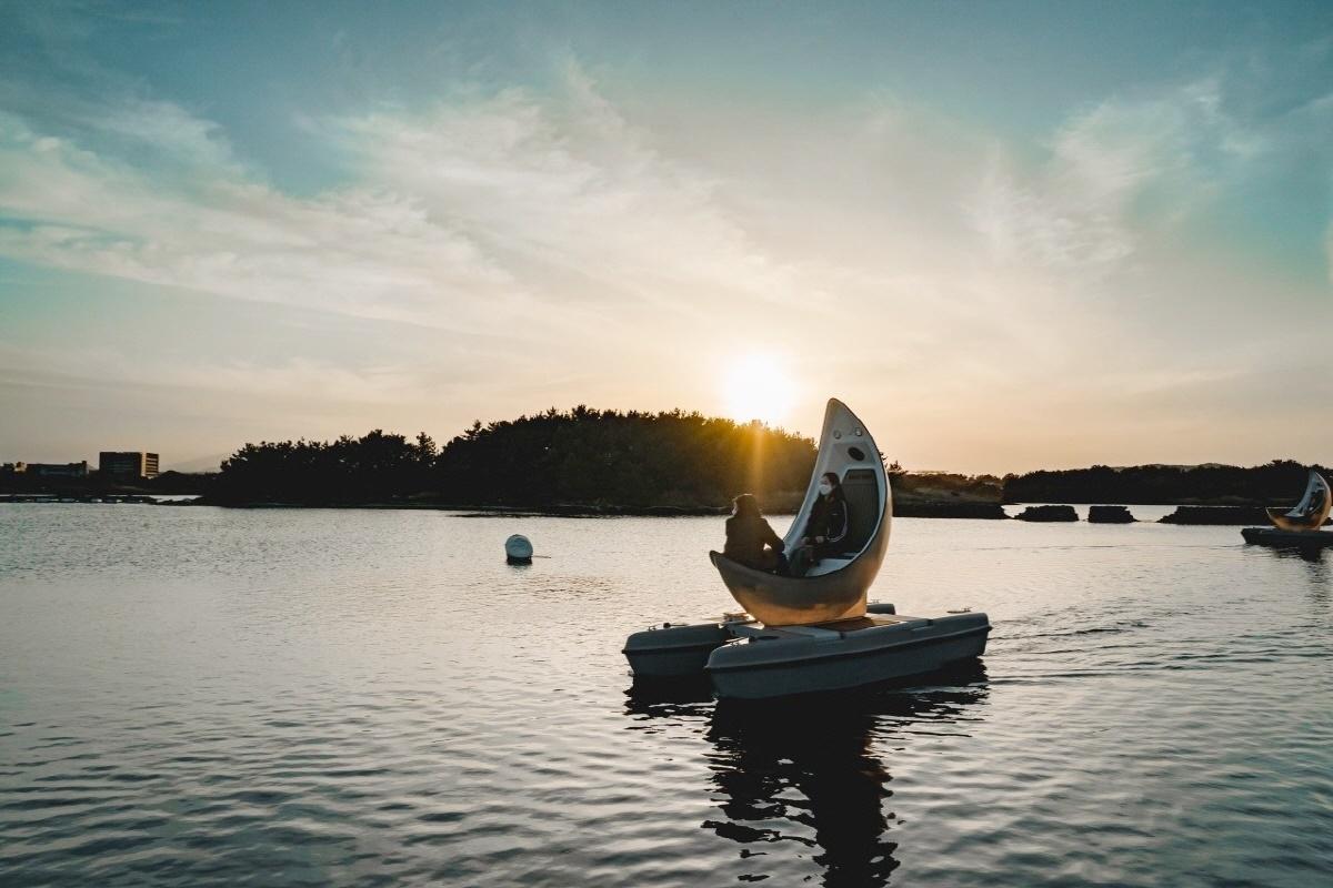 Bateau en forme de lune flottant sur l'eau sous un ciel au crépuscule à Jeju, Corée du Sud.