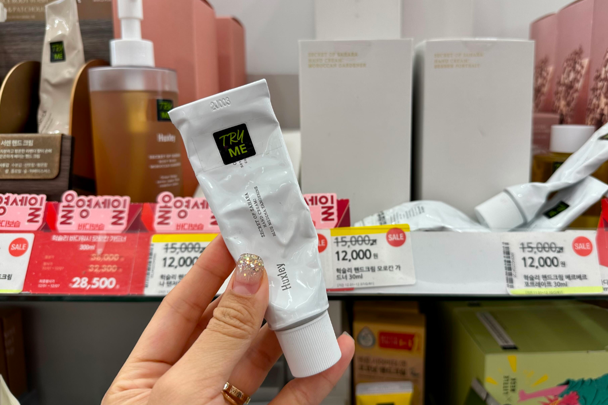 Kem dưỡng tay Huxley Perfume được trưng bày tại Olive Young, nổi bật với bảng giá và chương trình khuyến mãi, sử dụng dầu hạt xương rồng Sahara độc đáo cung cấp độ ẩm cao.