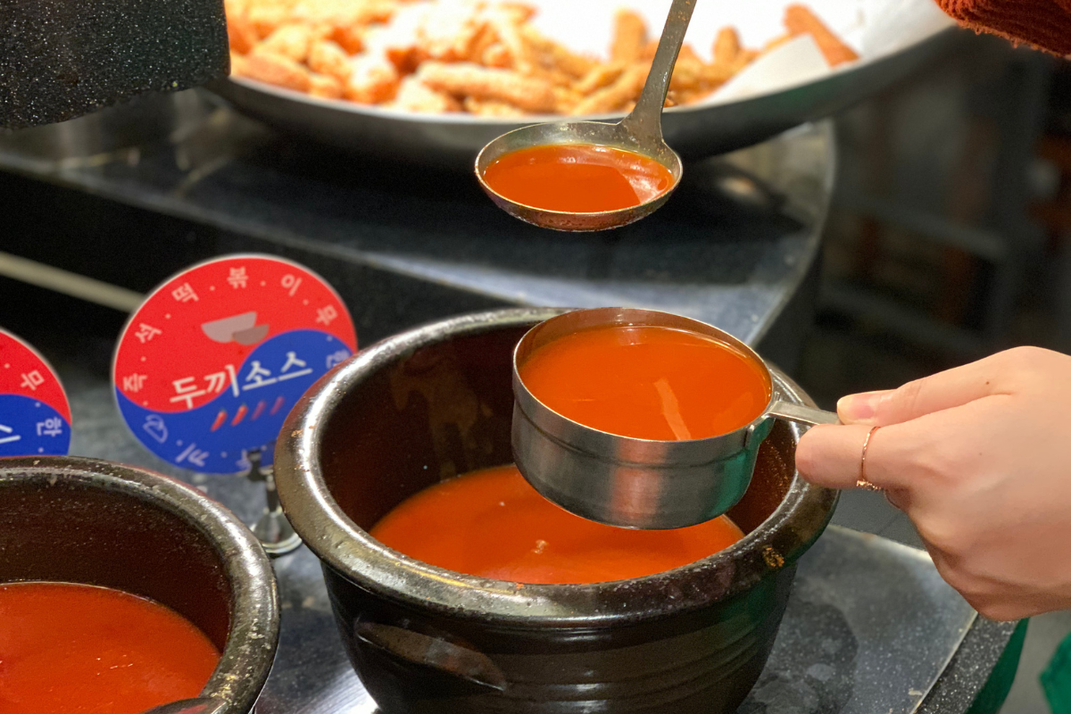 韓國料理愛好者正在享受美味豆製品年糕，搭配自製醬汁，呈現出一道色香味俱全的韓國經典小吃。這道年糕料理散發著迷人的香味，讓人口水直流，是享受韓國美食文化的絕佳體驗。