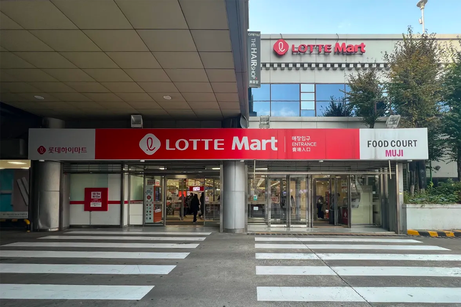 Lotte Mart entrance showcasing the store front with Lotte signage and entrance area, introducing the bustling atmosphere of a popular supermarket chain in Seoul.