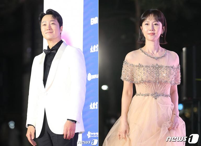 第58回大鐘賞映画祭で主演男優賞を受賞した俳優と主演女優賞を受賞した女優がレッドカーペットに立っている様子。