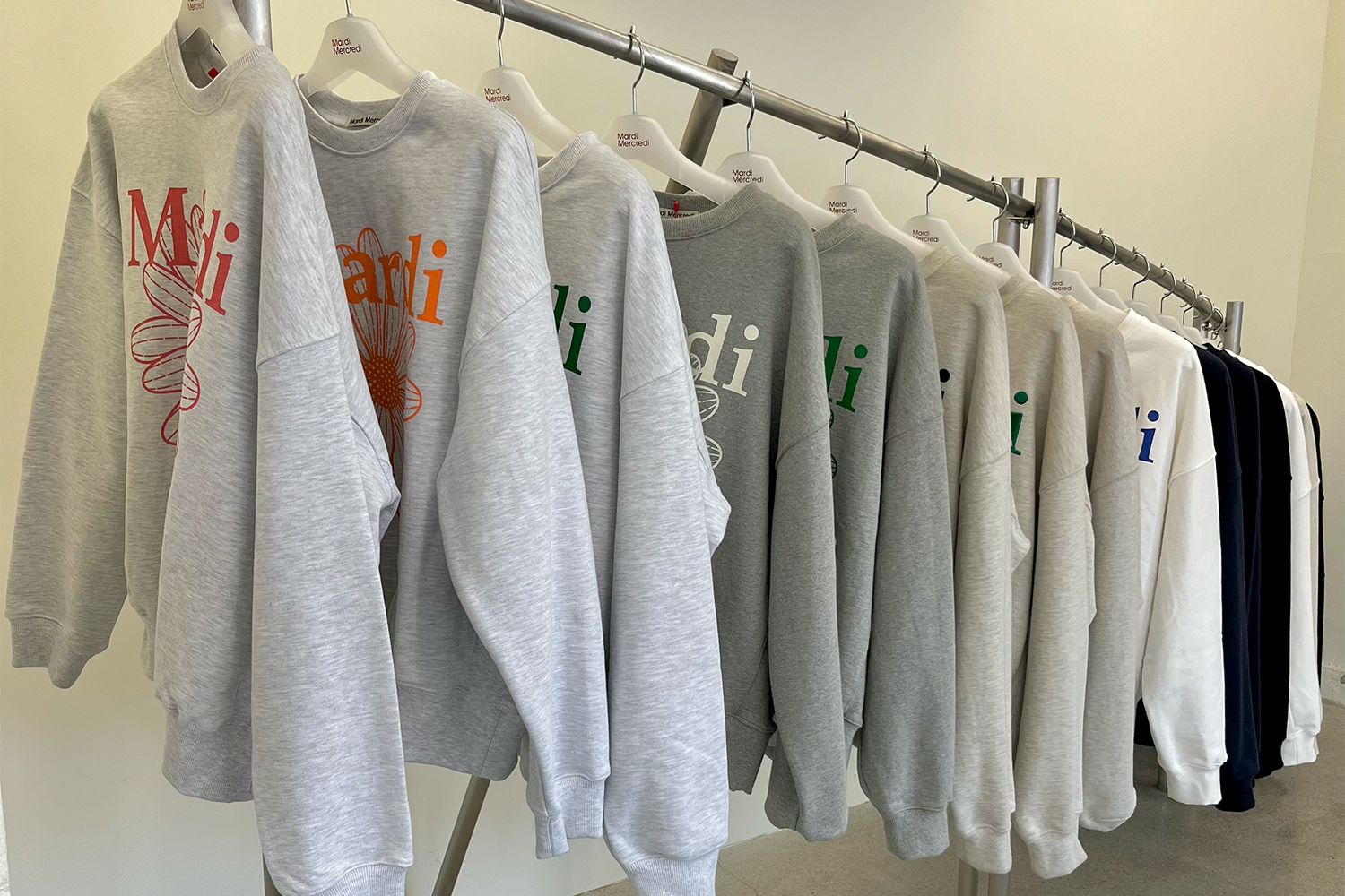 Mardi Mercredi展示架上整齊排列的灰色與彩色印花毛衣。
