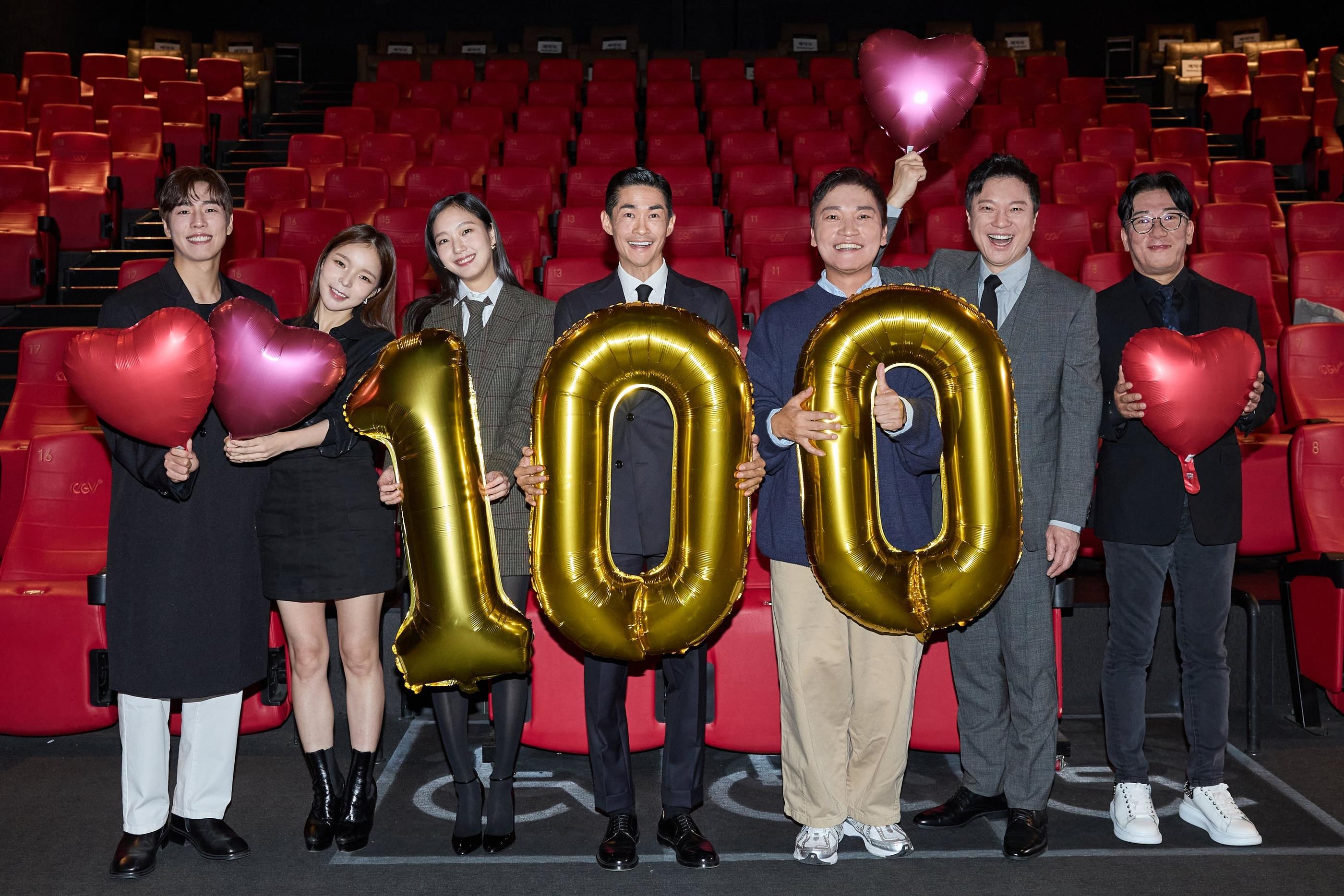 映画『英雄』が観客100万人を突破し、金色の100のバルーンとハート型のバルーンを持つ人々が映画館で記念写真を撮っています。