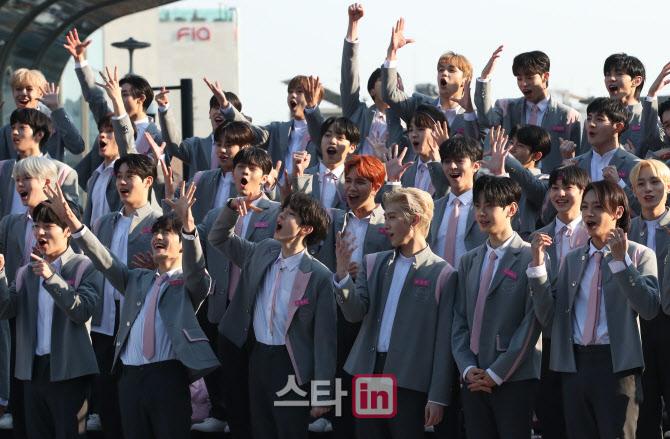 多くの参加者が上巌洞DMC文化公園で行われたMnet『BOYS PLANET』の魅力発表会に参加しています。制服姿の彼らがファンに向かって挨拶している姿が映し出されています。ファンやメディアが注目する重要なイベントの一幕です。