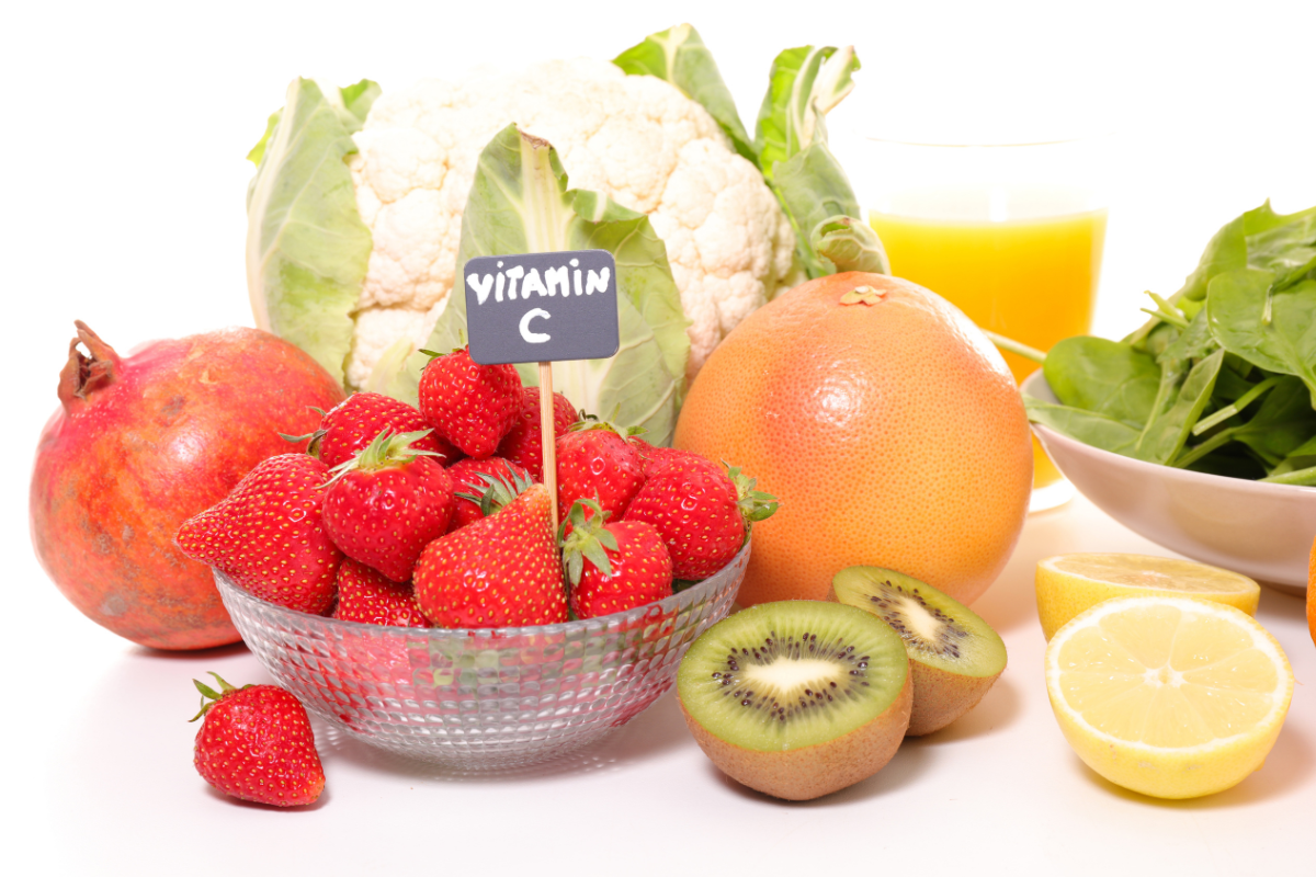 Giỏ đựng dâu tây cùng các loại hoa quả giàu vitamin C như cam, kiwi và rau xanh.