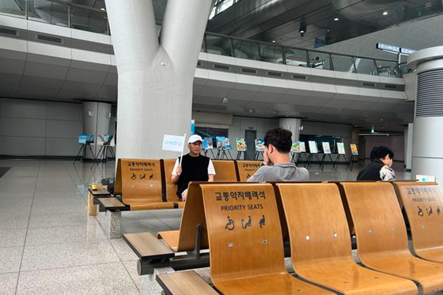 Creatrip服务员在仁川机场换汇服务区域坐着等候,带有指示牌子标志