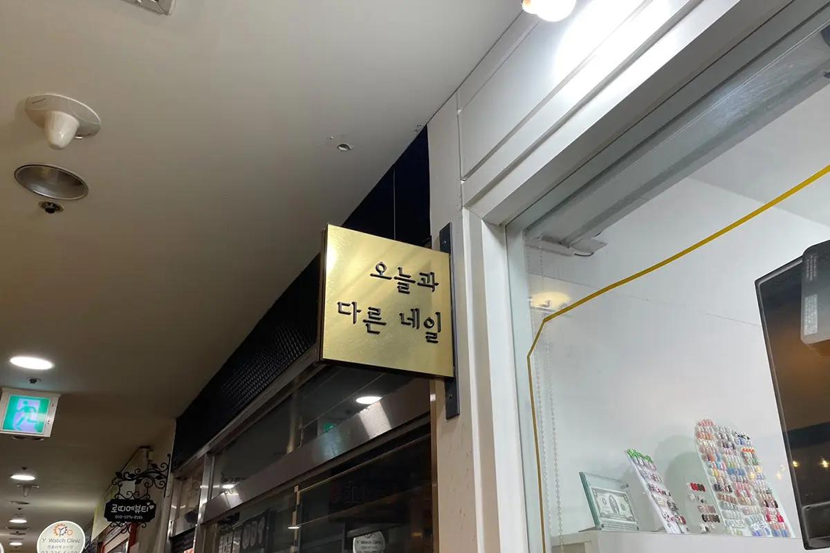 韓国ソウルのネイルサロン「今日と違うネイル」店舗入口の看板。テクスチャー効果がある看板デザインで目を引く。