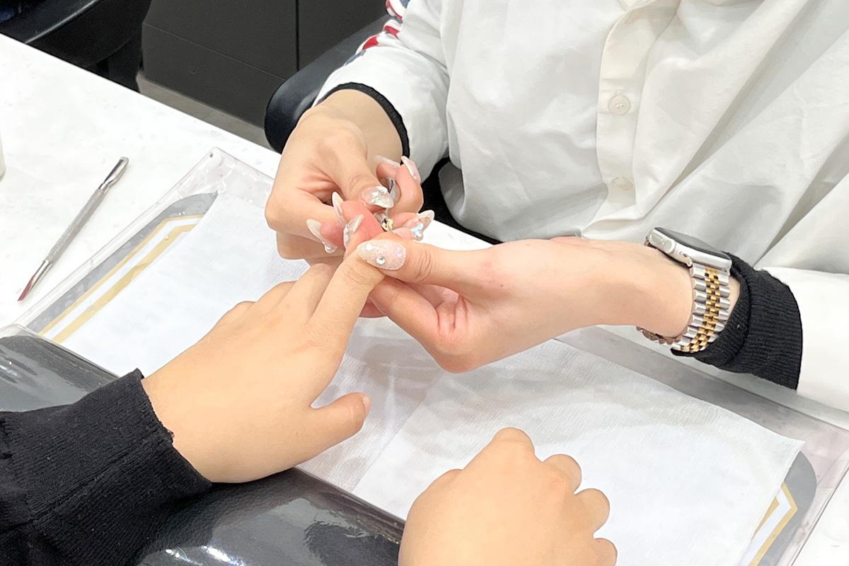 Technician enhances nail shine at Ohneulgwa Dareun Nail Salon, focusing on polishing and beauty.