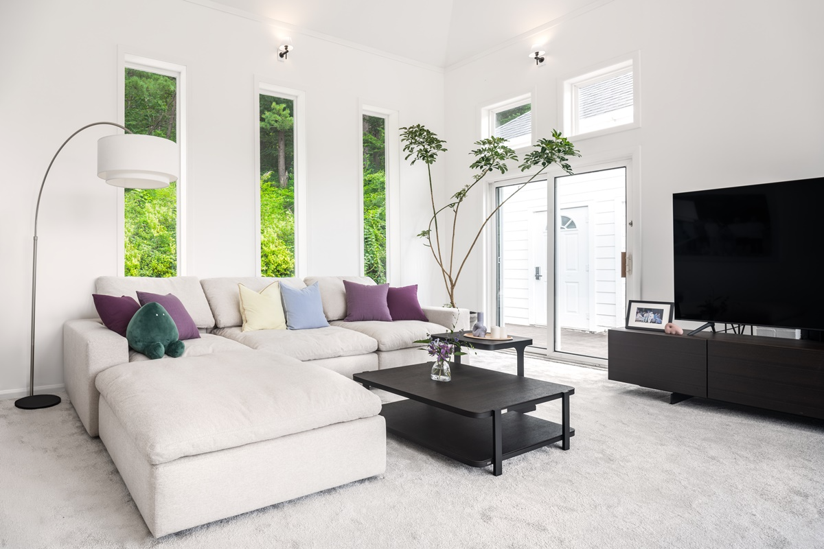 Interior modern dari rumah 'In the Soop' dengan sofa putih besar dan dekorasi elegan.