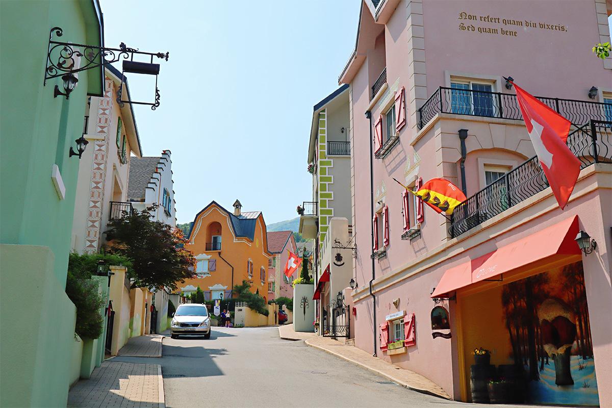 Jalan sempit dengan bangunan berwarna pastel di Edelweiss Swiss Theme Park.