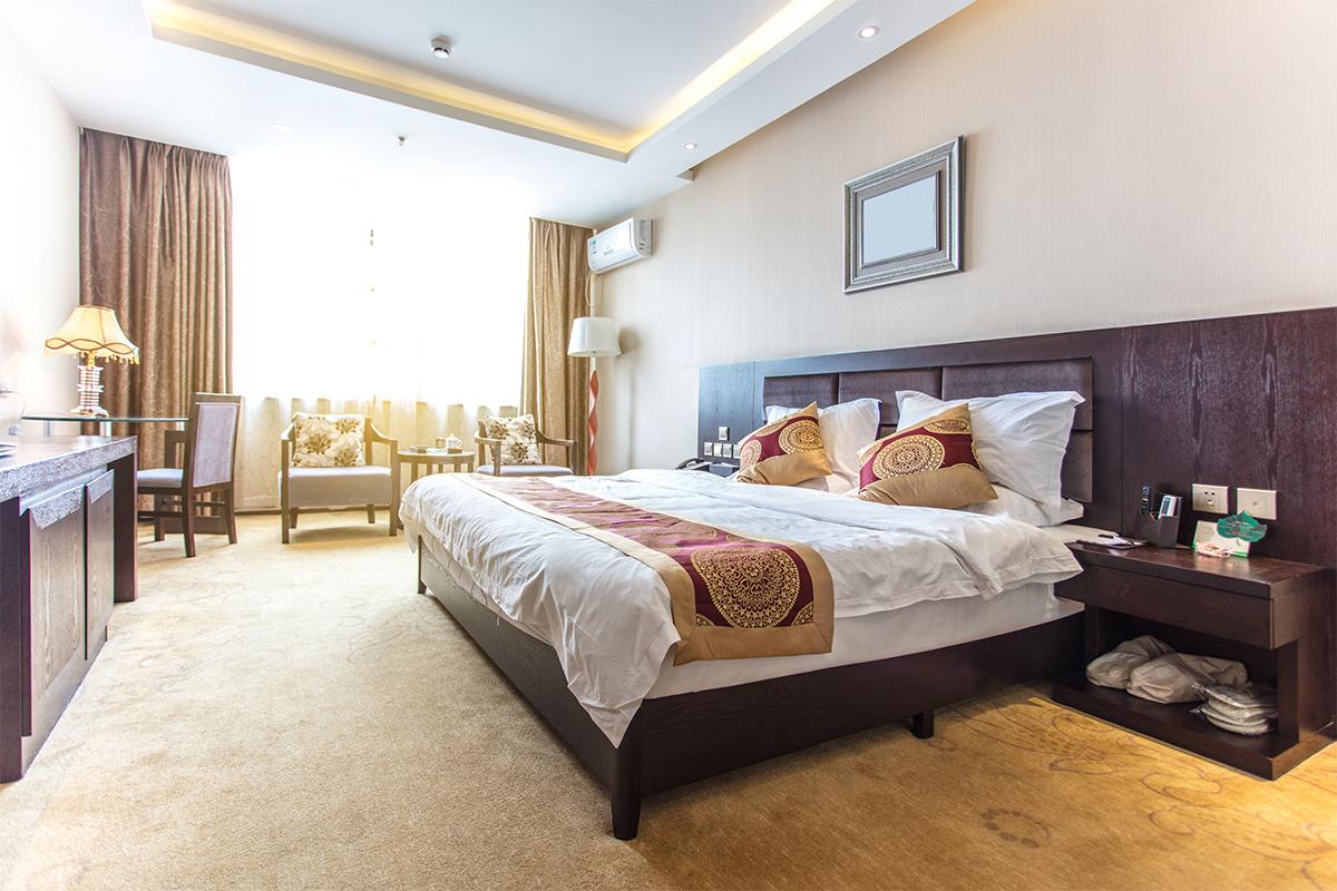 Kamar hotel yang nyaman dengan tempat tidur rapi dan pencahayaan alami yang hangat di Seoul, Korea Selatan.